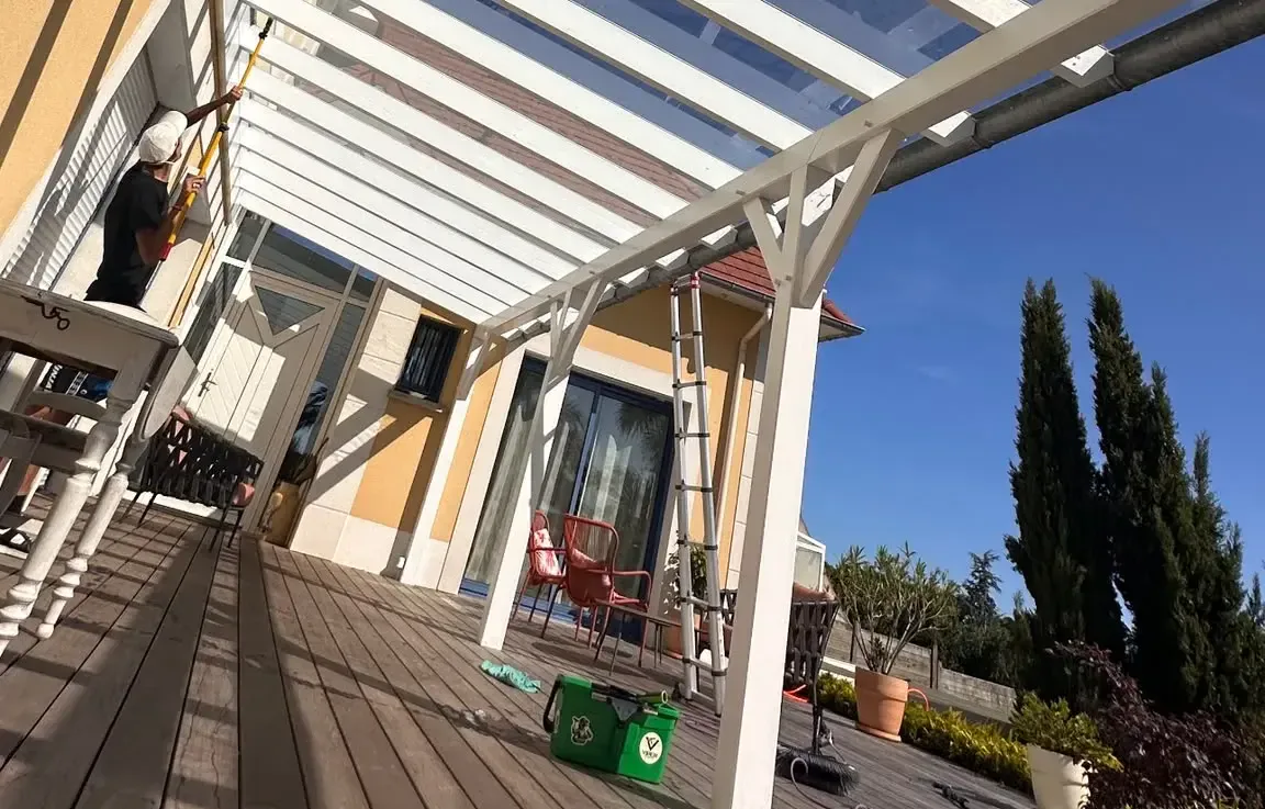 Nettoyage à la perche du toit vitré d'une pergola en bois