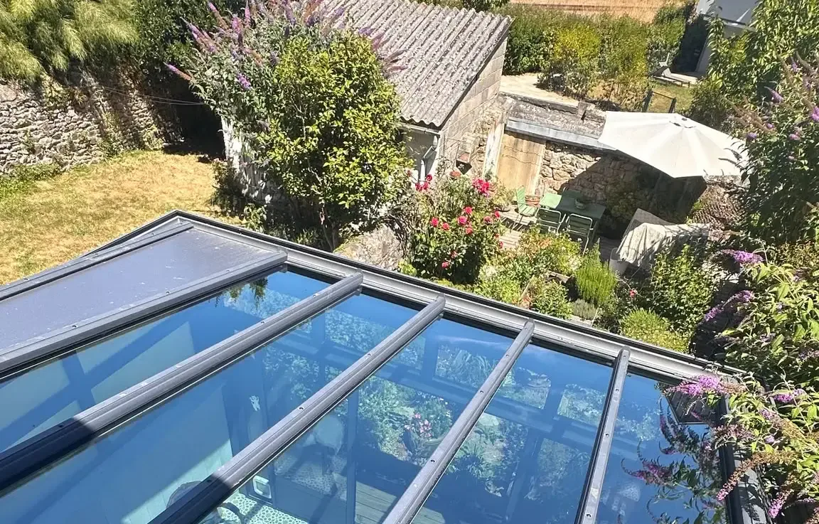 Toit de véranda vitré après nettoyage, vue plongeante sur les toits bretons